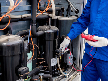 Technician maintaining HVAC equipment